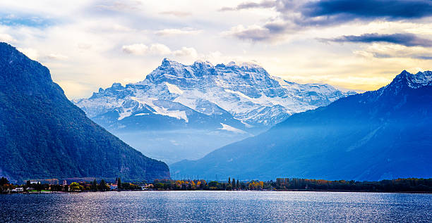A small boat sailing across a lake surrounded by mountains in Switzerland.